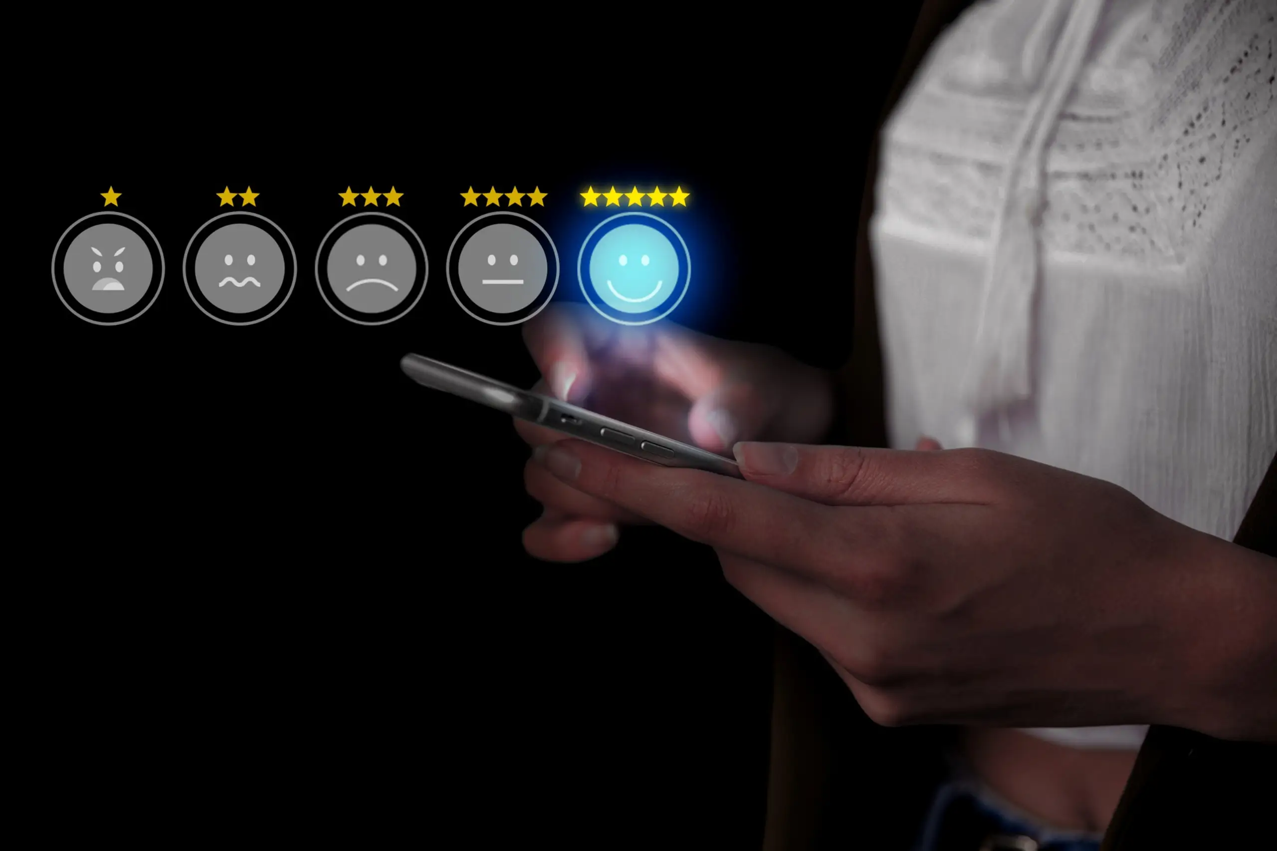 A person holds a smartphone, selecting a smiling emoji among five emotional icons to rate their experience